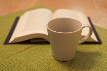 Cup of coffee and book in front of the window