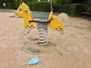 Masque chirurgical jeté dans une aire de jeux pour enfants pendant la pandémie de la Covid-19