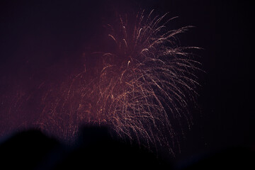 Small colourful festive fireworks above residential area, night cityscape