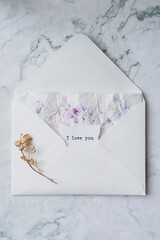romantic card with dried flowers and writing I love you
