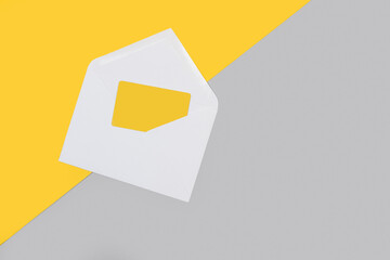 Sobre blanco abierto con una tarjeta amarilla sobre un fondo liso amarillo y gris. Vista superior. Copy space