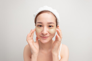 Indoor shot of calm relaxed woman has fresh healthy skin, wears collagen patches under eyes