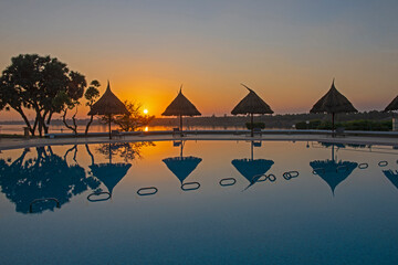 Swimming pool at a luxury tropical hotel resort at sunset