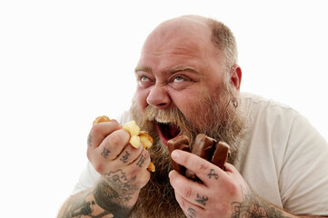 Closeup portrait of an overweigh man squeezing cake and chocolate bars into his fists feeling...