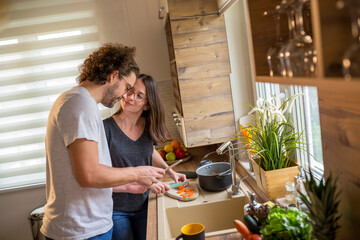 Couple checking recipe using tablet computer while cooking lunch