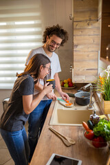 Couple having fun while cooking togehter in kitchen