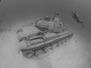 scuba diver exploring tank wreck underwater