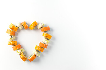 Sushi rolls in the form of a heart on a white background. Valentine's Day. Horizontal orientation, copy space.