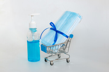 Alcohol gel and Medical masks lie in a shopping trolley,Concept of choosing and buying new year festival in safety on white background