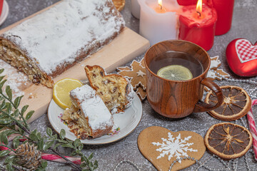 Obraz na płótnie Canvas Christmas roll, tea with lemon in a wooden mug. New Year's tinsel. Celebratory still life.