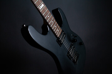 Fototapeta na wymiar Black electric guitar on a dark background with backlit strings
