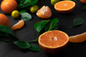 Fresh picked mandarins with leaves on black background.