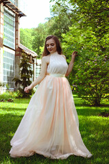 Obraz premium Portrait of young attractive woman walking in spring garden in sunny day. Spring background. Woman's Day. Greeting card. 