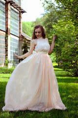 Obraz premium Portrait of young attractive woman walking in spring garden in sunny day. Spring background. Woman's Day. Greeting card. 
