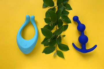Sex toys. Blue vibrator and butt plug on a yellow background. Useful for adult, sex shop