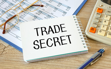 Trade Secret is written on a notepad on an office desk