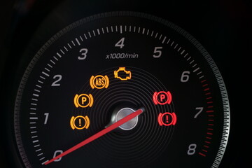 Close up of tachometer dial with warning lights on a car