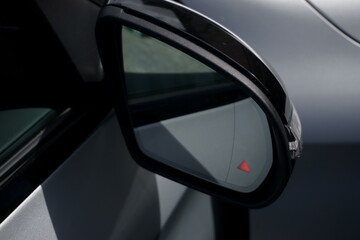 Car door mirror with illuminated blind spot monitoring light warning. - obrazy, fototapety, plakaty