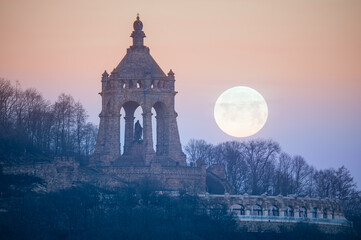 The moon setting behind the Kaiser Wilhelm Monument in Porta Westfalica