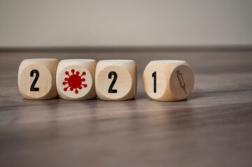 Cubes, dice or blocks with syringe metaphor for vaccination start against covid-19 corona virus on wooden background