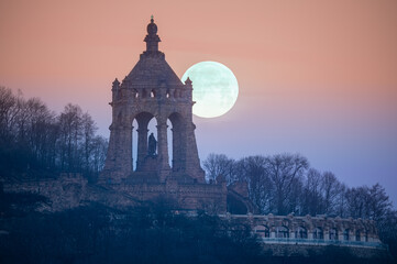 The moon setting behind the Kaiser Wilhelm Monument in Porta Westfalica