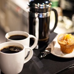 french press coffee with two mugs and muffin