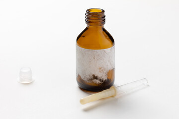 Glass medical brown bottle with torn off label and pipette