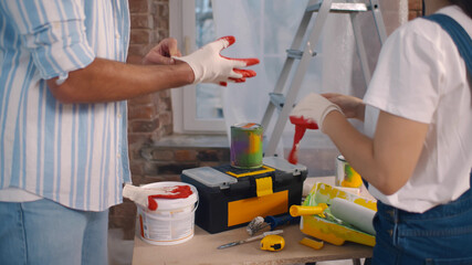 Happy young couple putting on gloves doing house redecoration