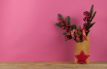 Christmas card with red berries and a pine cone on a wood table background. Composition of Christmas holidays.