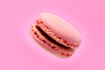 Pink berry filling french macaroon is flying on purple background