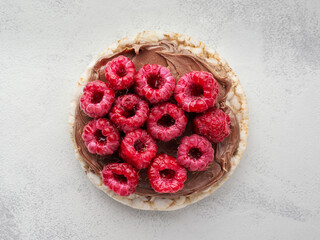 Rice cakes with chocolate nut paste and raspberries top view close up