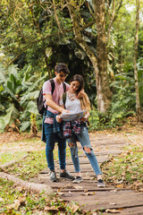 Couple of hikers reading the map in the forest - Cheerful hikers looking at map and looking for right way.