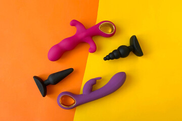 Sex toys. Vibrators and butt plags. Orange background. Useful for adult, sex shop