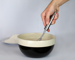 Whisking in a cooking bowl close up of hand