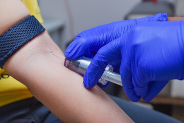 doctor injecting venipuncture injection on woman's armpit with safety precaution for covid -19 test...