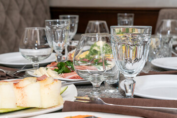 Festive table setting, family dinner with served italian antipasti - marinated salmon, hamon, Carpaccio, pear, basil. Tablescape.