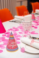 A beautiful set table for a children's birthday. Empty plates with cutlery and tops with the words 'Happy Birthday'.