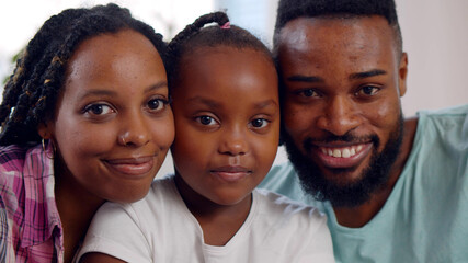 Close up portrait of joyful african american parents with cute preteen daughter