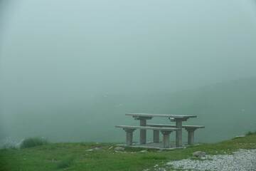 COPY SPACE: Empty picnic table and benches are surrounded by thick white fog.