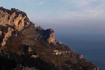 Sunset panorama of  Amalfi coast, view from the path of the Gods,  with the characteristic terraces cultivated with citrus, vines and olive trees along the slopes, Campania, southern Italy, europe