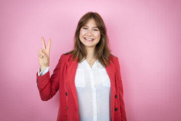 Young business woman over isolated pink background showing and pointing up with fingers number two while smiling confident and happy