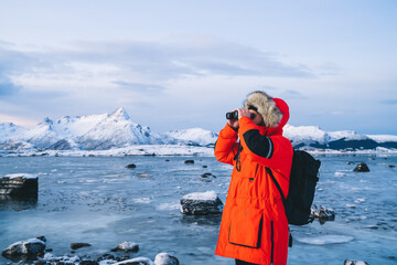 Anonymous tourist with binocular exploring wild coast