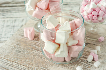 Assorted pink and white marshmallows in glass cups on wooden background. Heart shape marshmallow for hot chocolate or cacao