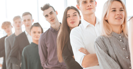 Fototapeta premium group of serious young people standing in a long queue