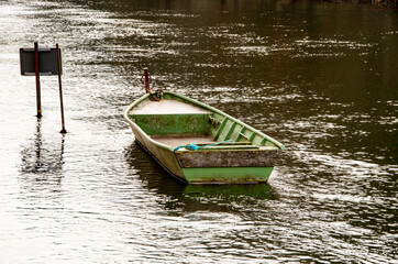 Old rowing boat lies moored in the river. High quality photo
