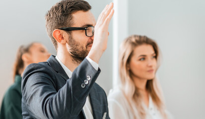 close up. a young businessman asks a question during a business