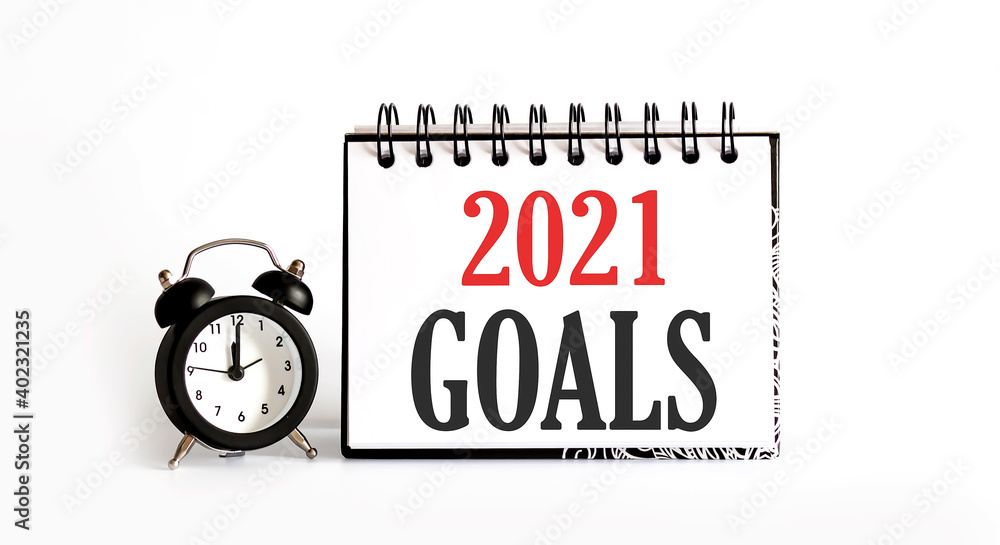 Poster 2021 goals notepad writing on the white background with alarm clock