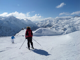 Fototapeta na wymiar Skifahrerein vor Berglandschaft auf der Piste. Kitzbühel in Tirol, Österreich. Frau Sportlerin Wintersport Abfahrt Piste.