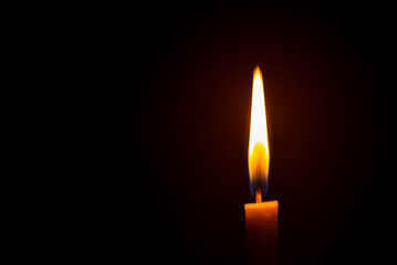 Close up single candle light and flame on black background
