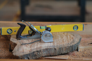 Spirit level, measuring tape and planer on slab coffee table. Woodworking and carpentry production....